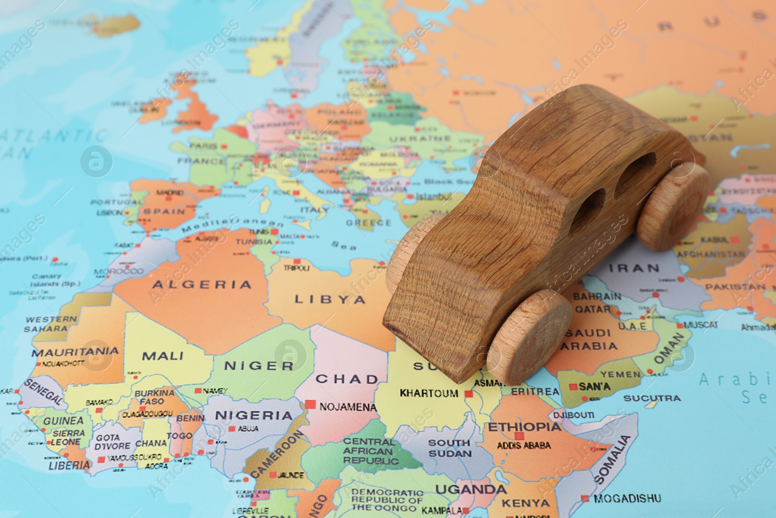 Photo of Wooden toy car on world map. Road trip