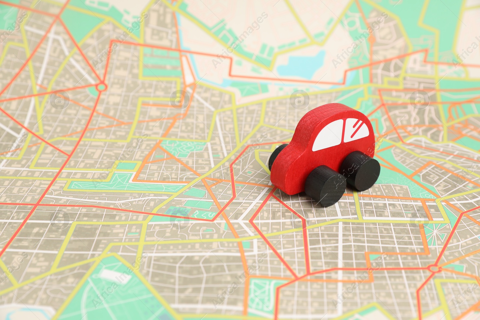 Photo of Red toy car on city map. Road trip