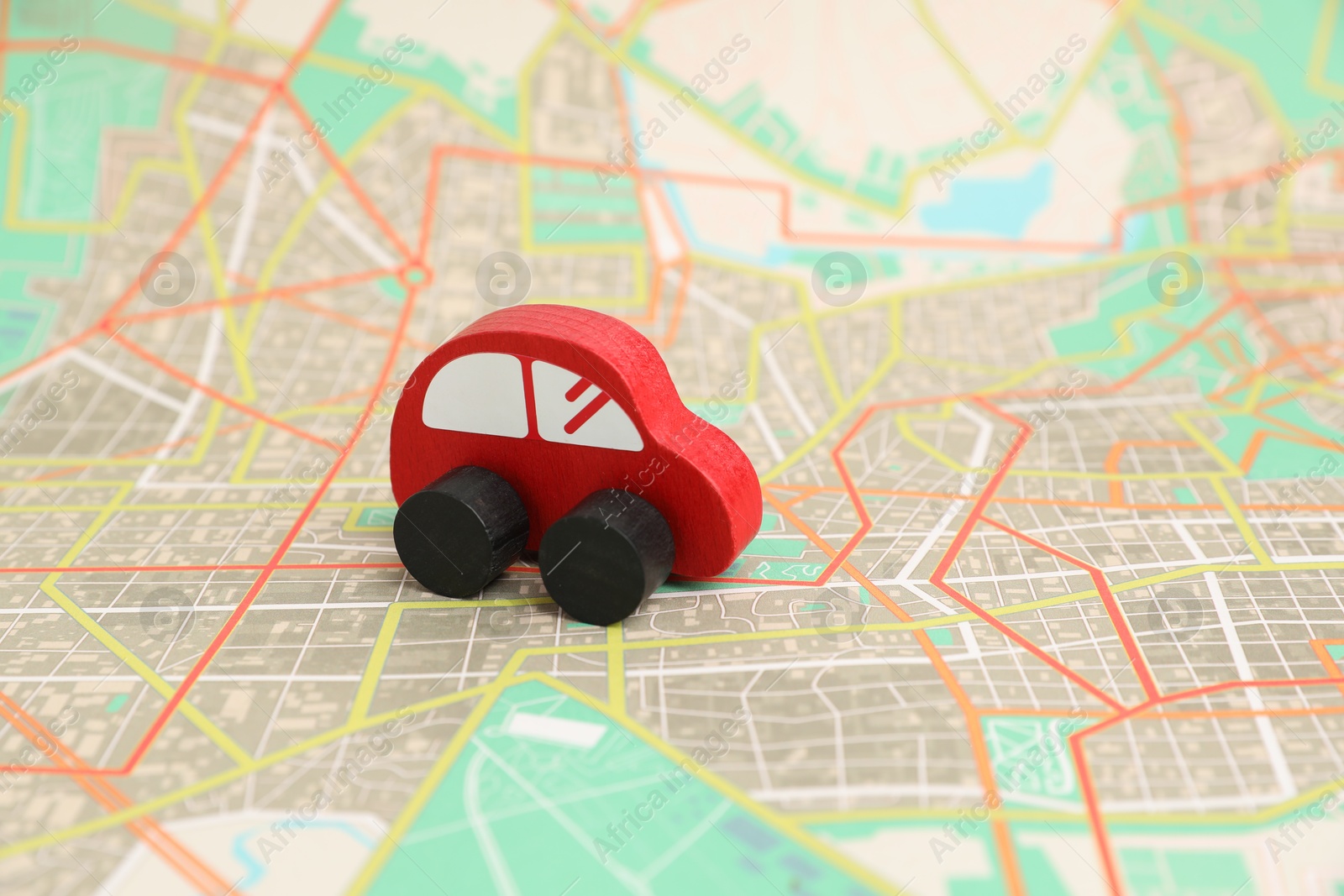 Photo of Red toy car on city map. Road trip