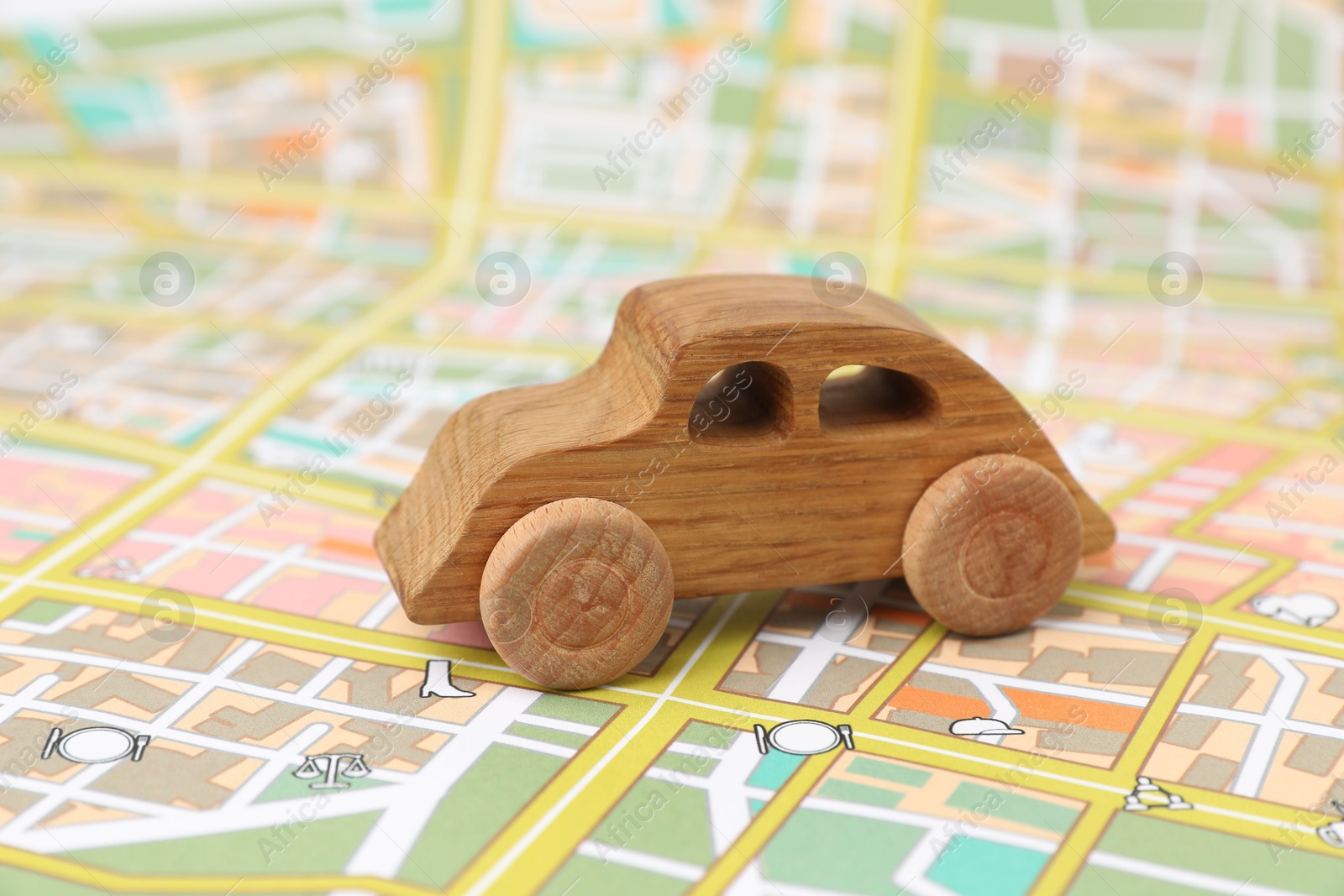 Photo of Wooden toy car on city map. Road trip