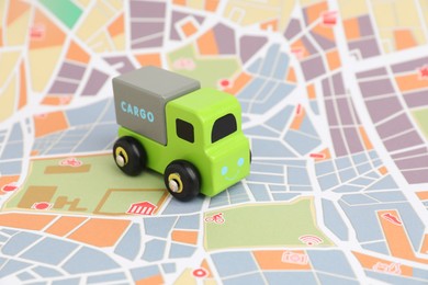 Photo of Toy truck on city map. Logistics concept