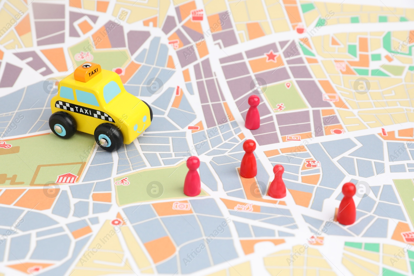 Photo of Yellow taxi car and red human figures on city map