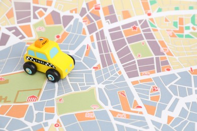 Photo of Yellow taxi car on city map. Road trip