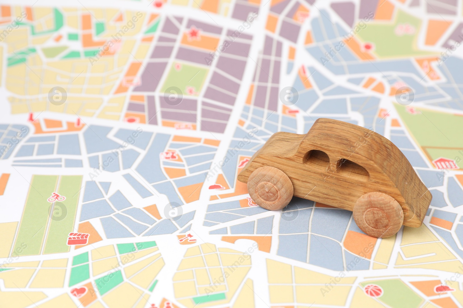 Photo of Wooden toy car on city map. Road trip