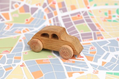 Photo of Wooden toy car on city map. Road trip