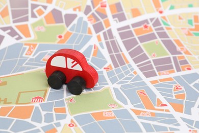 Photo of Red toy car on city map. Road trip