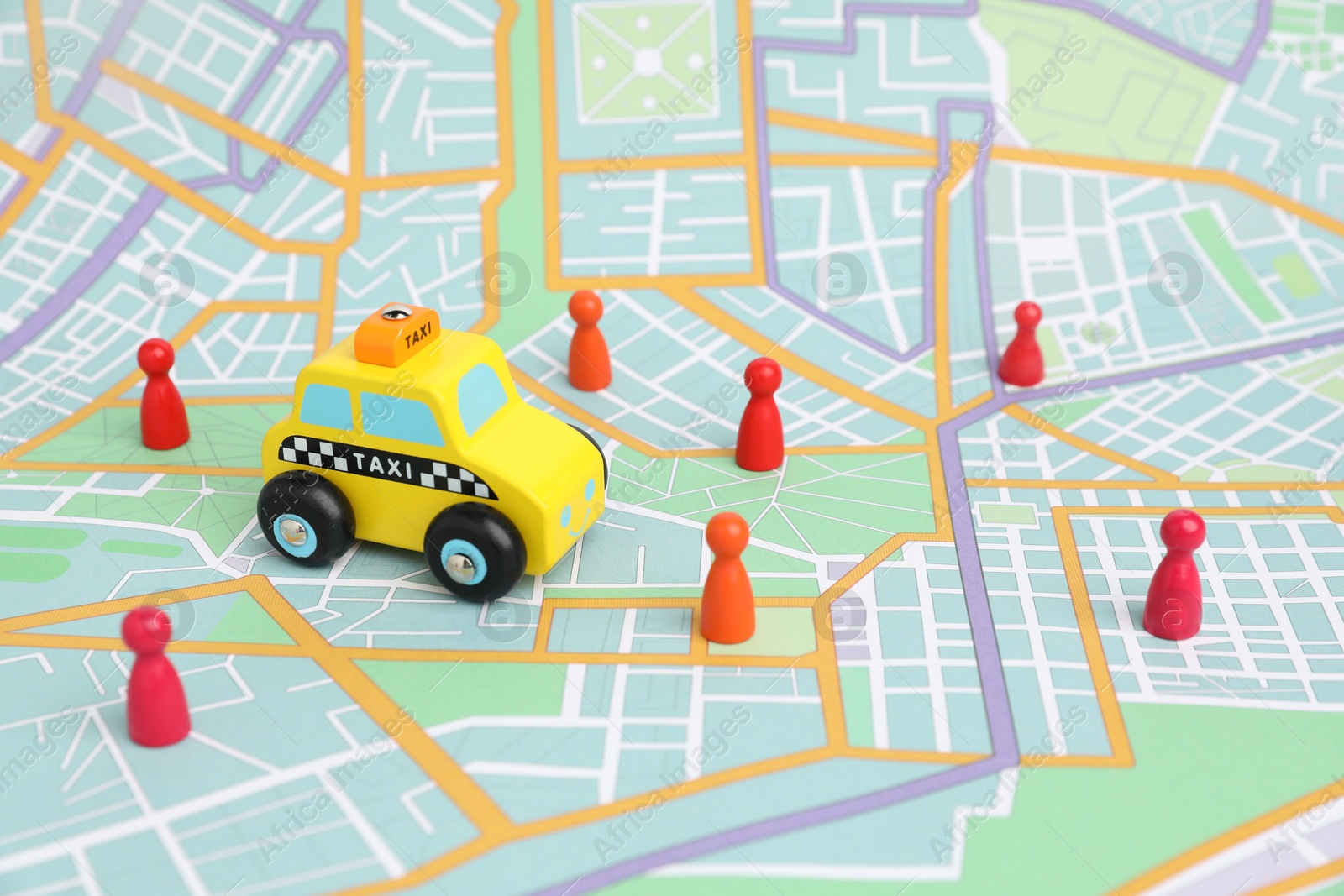 Photo of Yellow taxi car and colorful human figures on city map