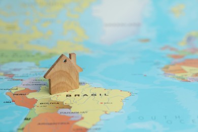 Photo of Wooden house model on world map. Accommodation search