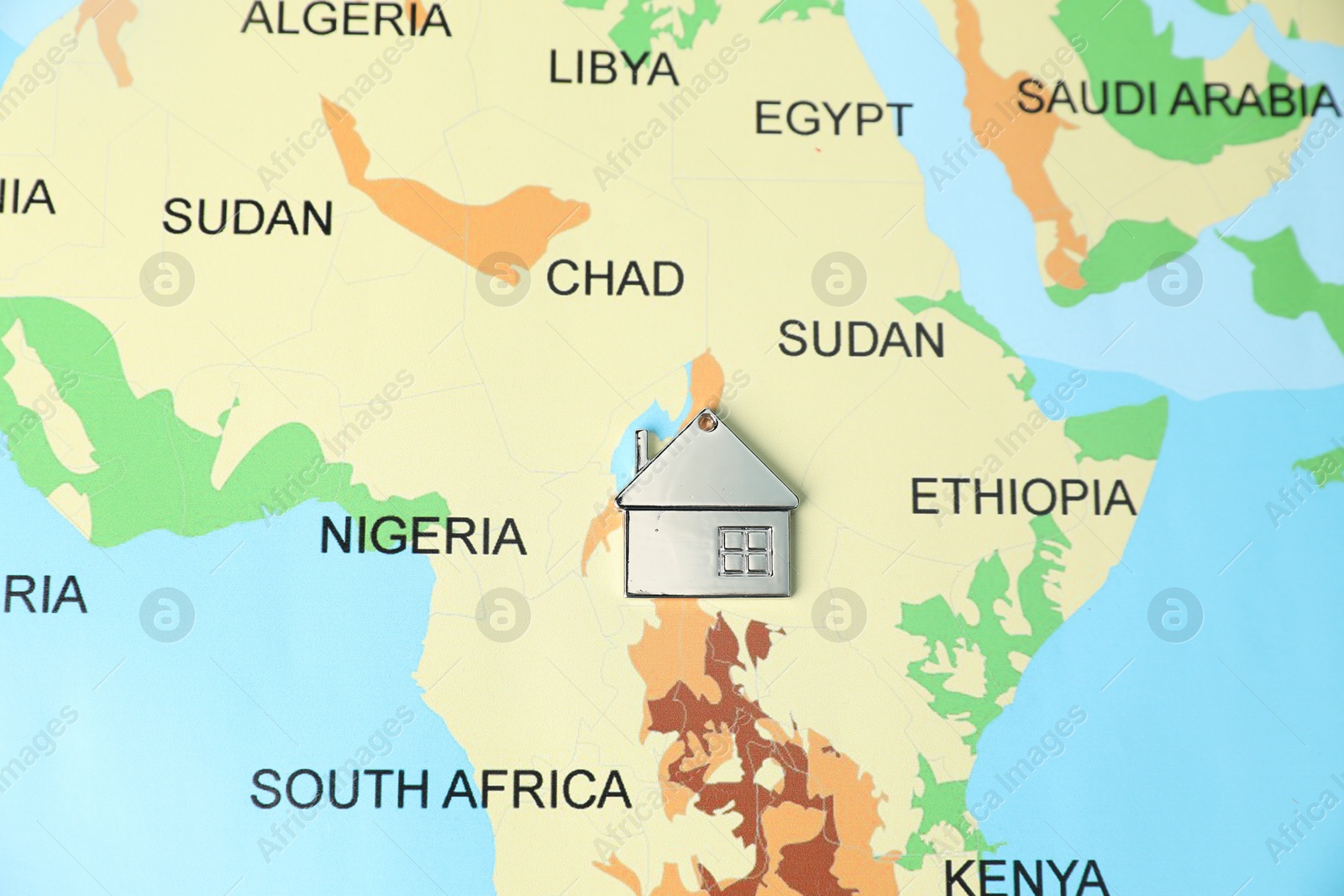 Photo of Metal house model on world map, top view. Accommodation search