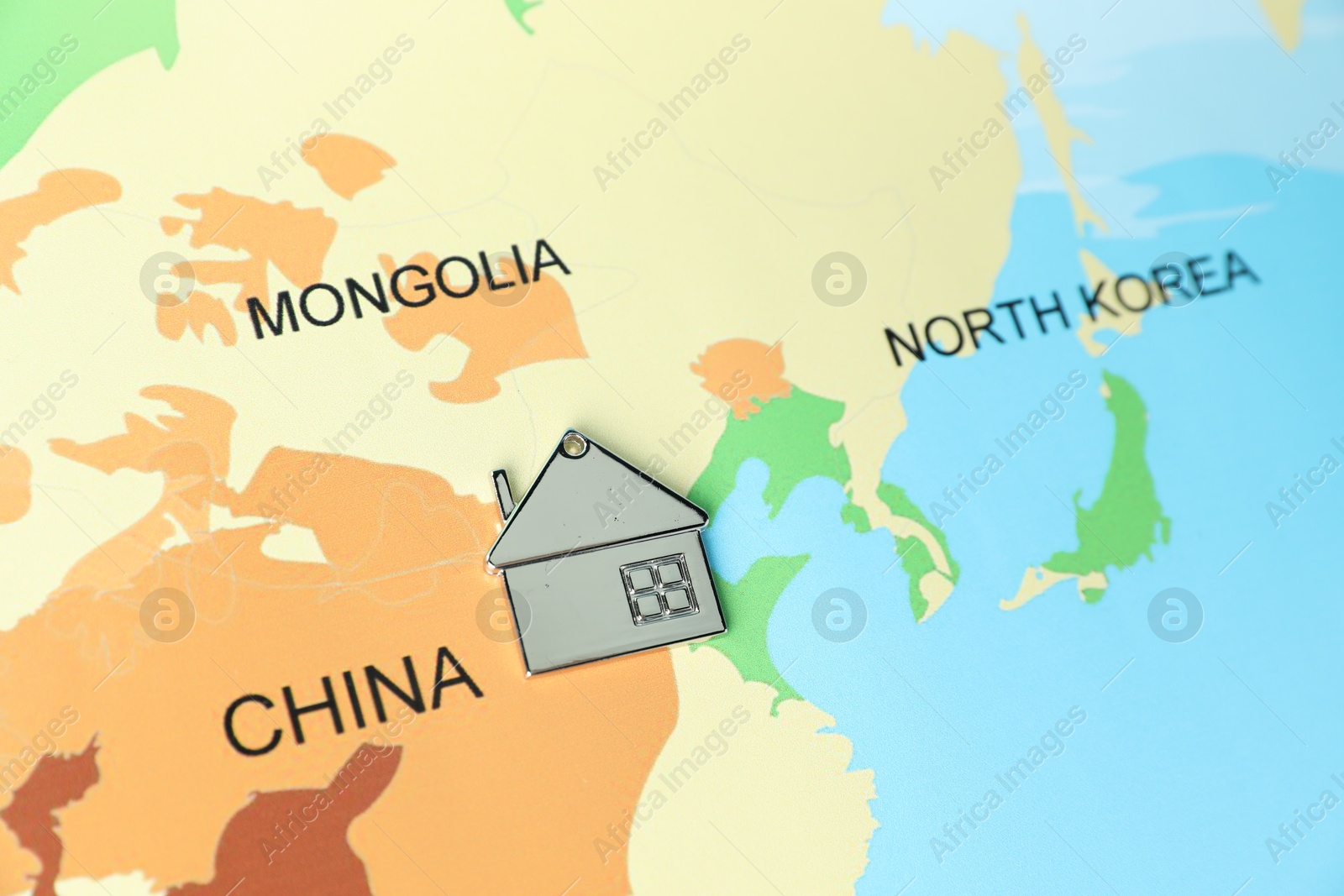 Photo of Metal house model on world map, above view. Accommodation search