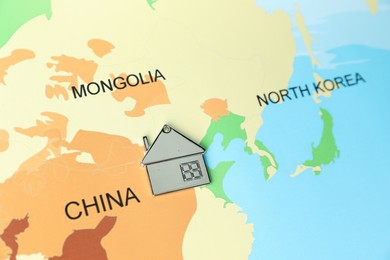 Photo of Metal house model on world map, above view. Accommodation search