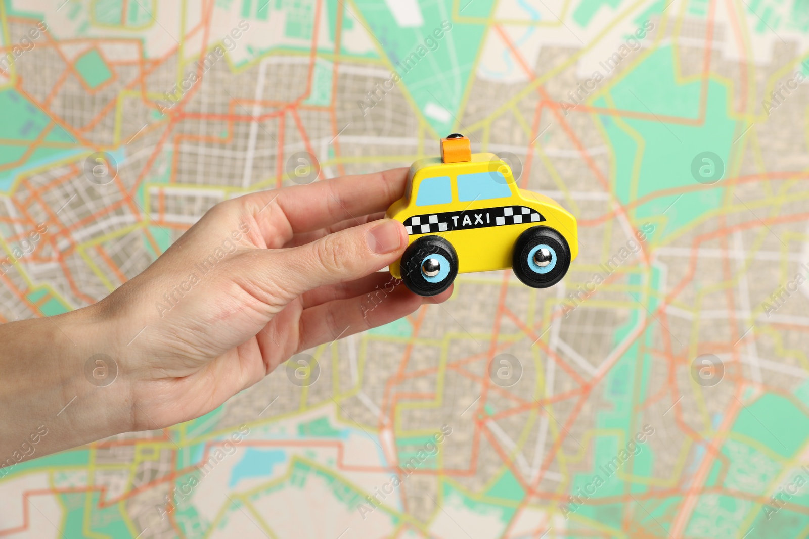 Photo of Woman with yellow taxi car against city map, closeup