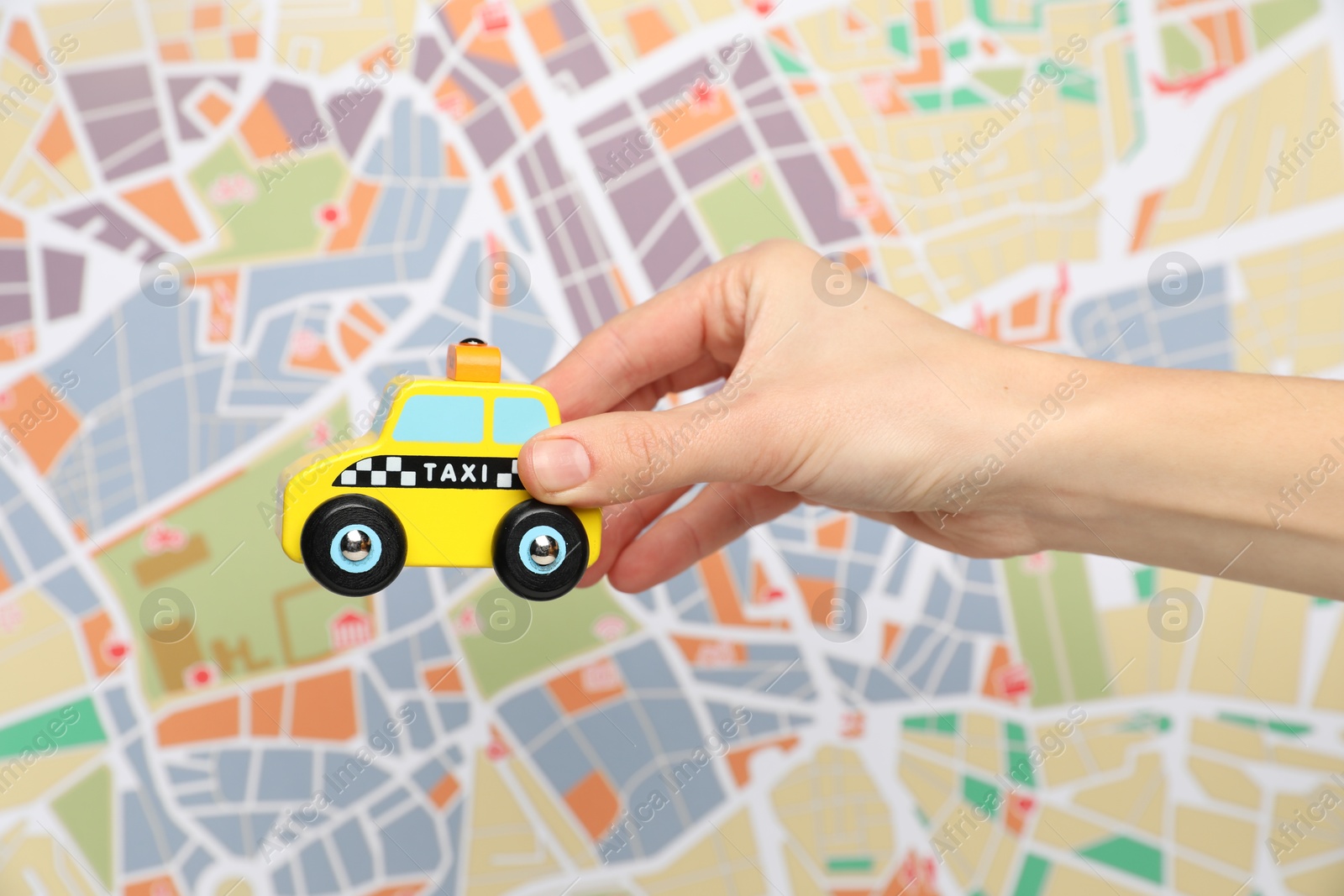 Photo of Woman with yellow taxi car against city map, closeup