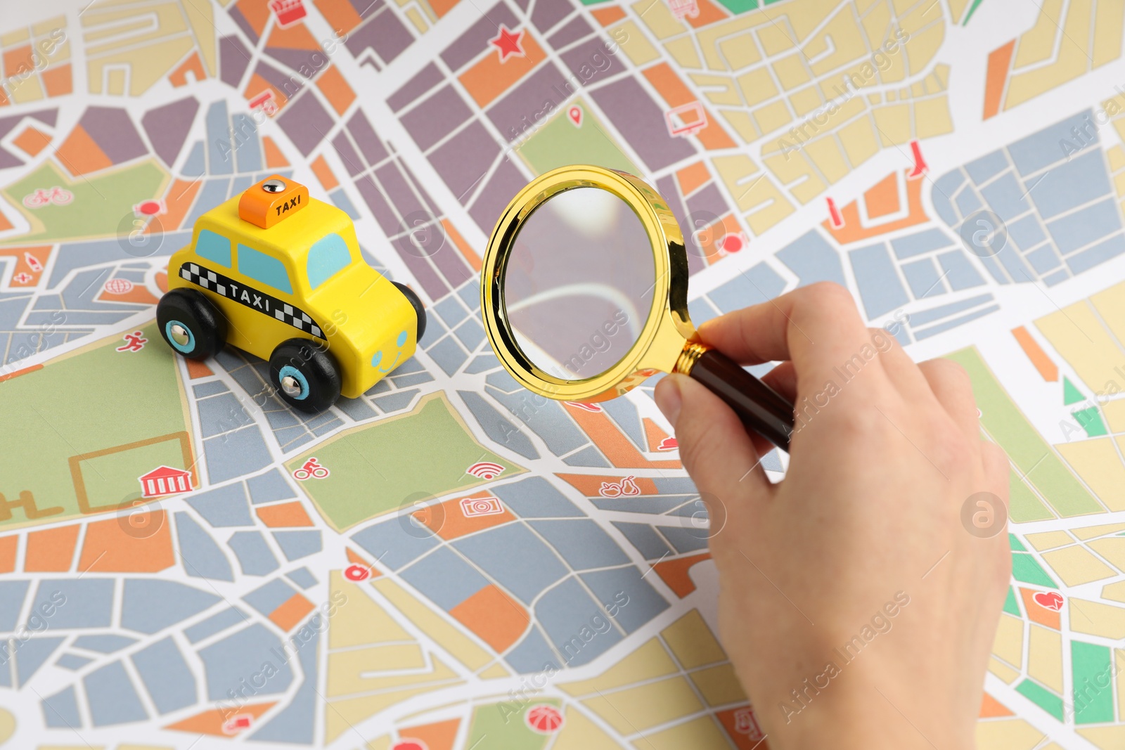 Photo of Woman looking at city map through magnifying glass, closeup. Road trip