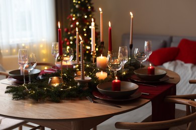 Photo of Festive table setting in room decorated for Christmas. Bokeh effect