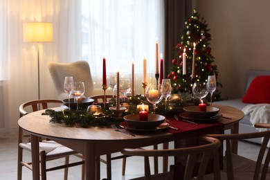 Photo of Festive table setting in room decorated for Christmas. Bokeh effect