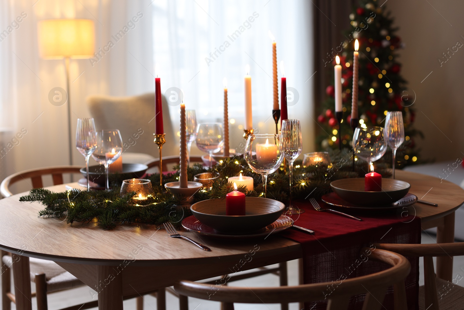 Photo of Festive table setting in room decorated for Christmas. Bokeh effect