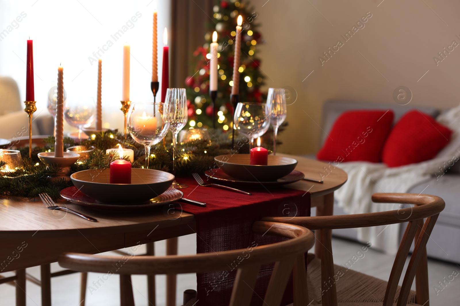 Photo of Festive table setting in room decorated for Christmas. Bokeh effect