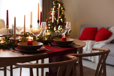 Photo of Festive table setting in room decorated for Christmas. Bokeh effect