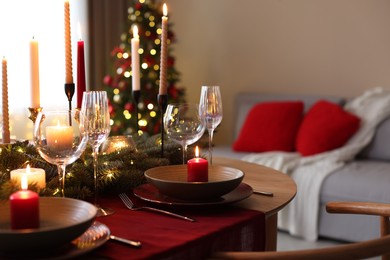 Photo of Festive table setting in room decorated for Christmas. Bokeh effect