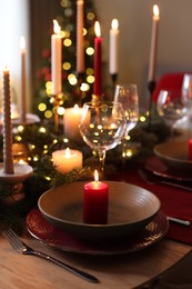 Photo of Festive table setting in room decorated for Christmas, closeup. Bokeh effect