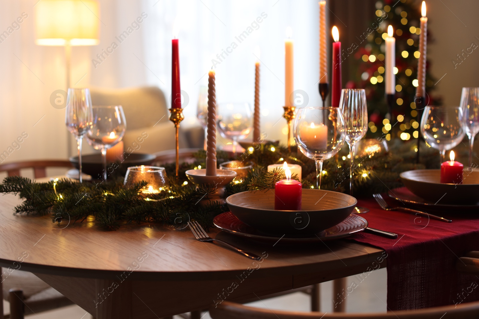 Photo of Festive table setting in room decorated for Christmas. Bokeh effect