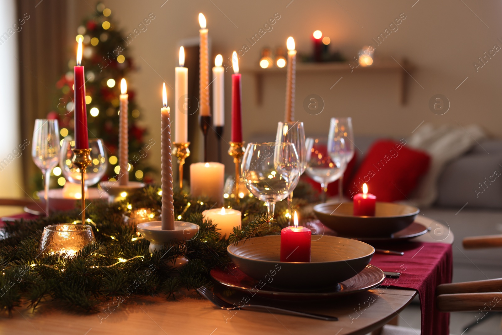 Photo of Festive table setting in room decorated for Christmas. Bokeh effect