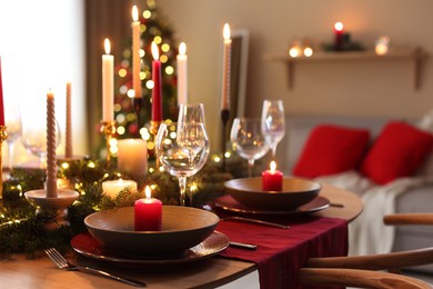 Photo of Festive table setting in room decorated for Christmas. Bokeh effect