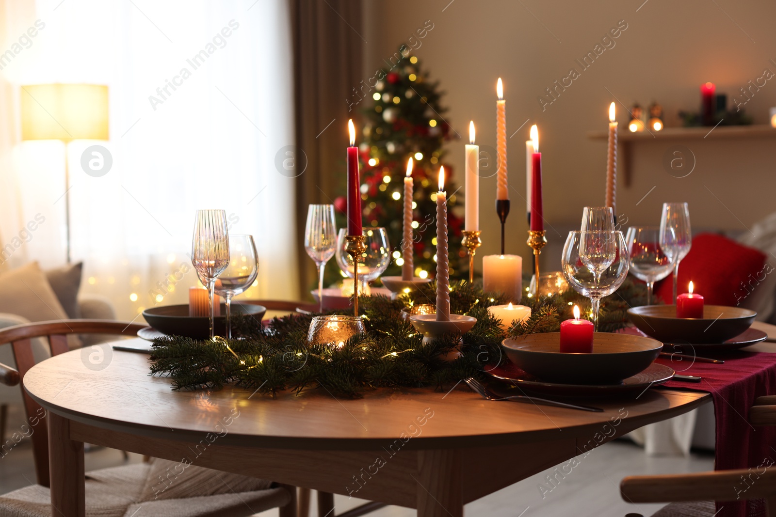 Photo of Festive table setting in room decorated for Christmas. Bokeh effect