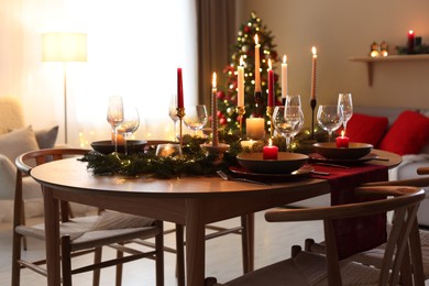 Photo of Festive table setting in room decorated for Christmas. Bokeh effect