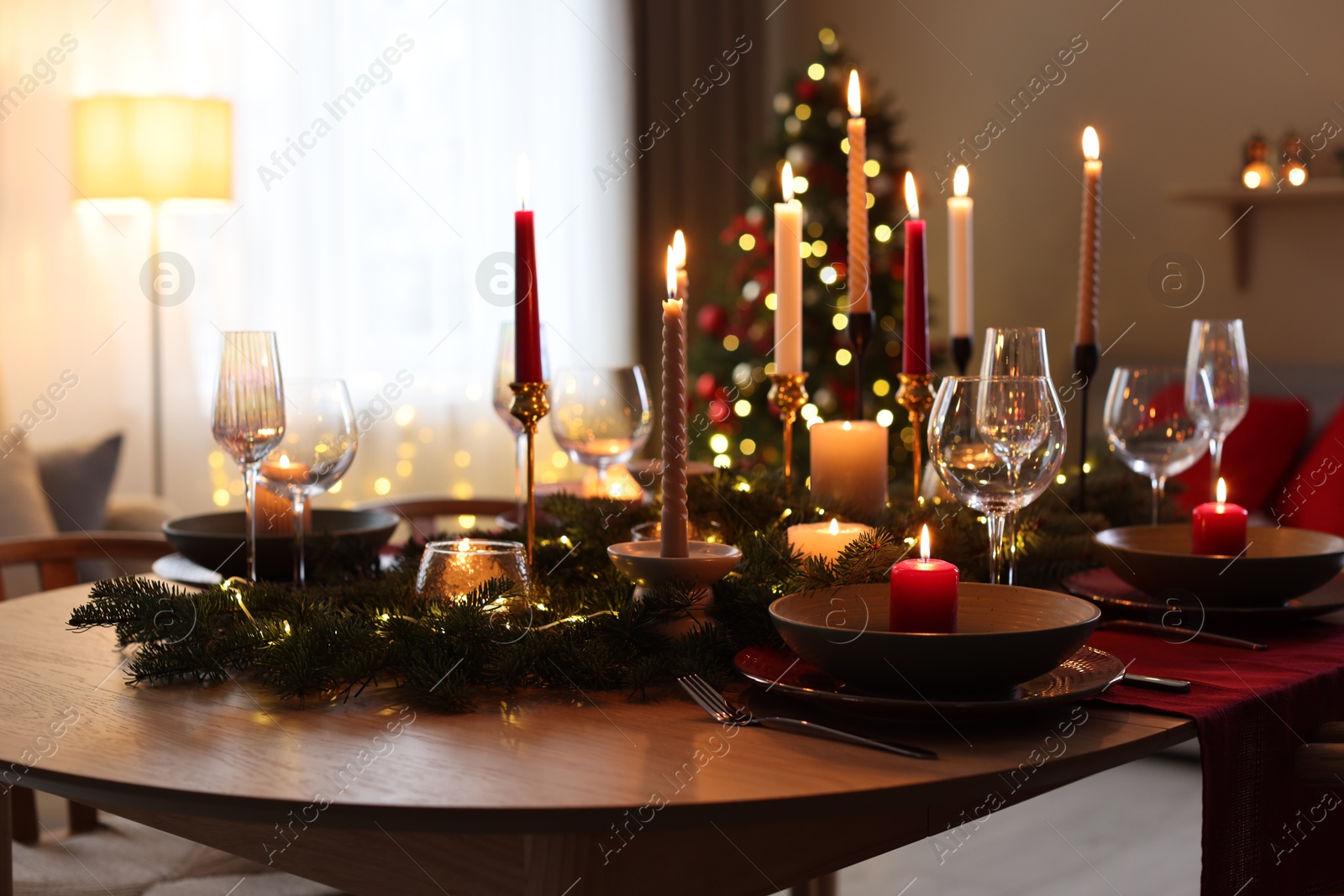 Photo of Festive table setting in room decorated for Christmas. Bokeh effect