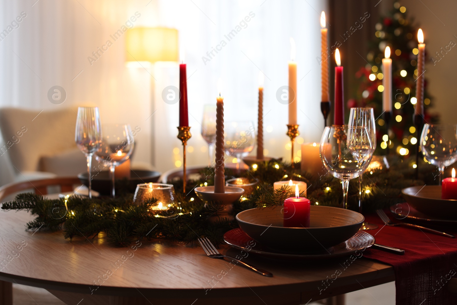 Photo of Festive table setting in room decorated for Christmas. Bokeh effect