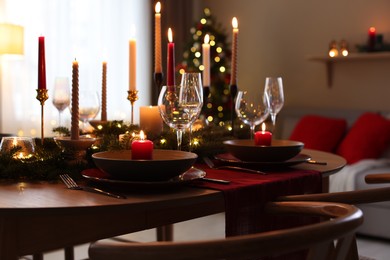 Photo of Festive table setting in room decorated for Christmas. Bokeh effect