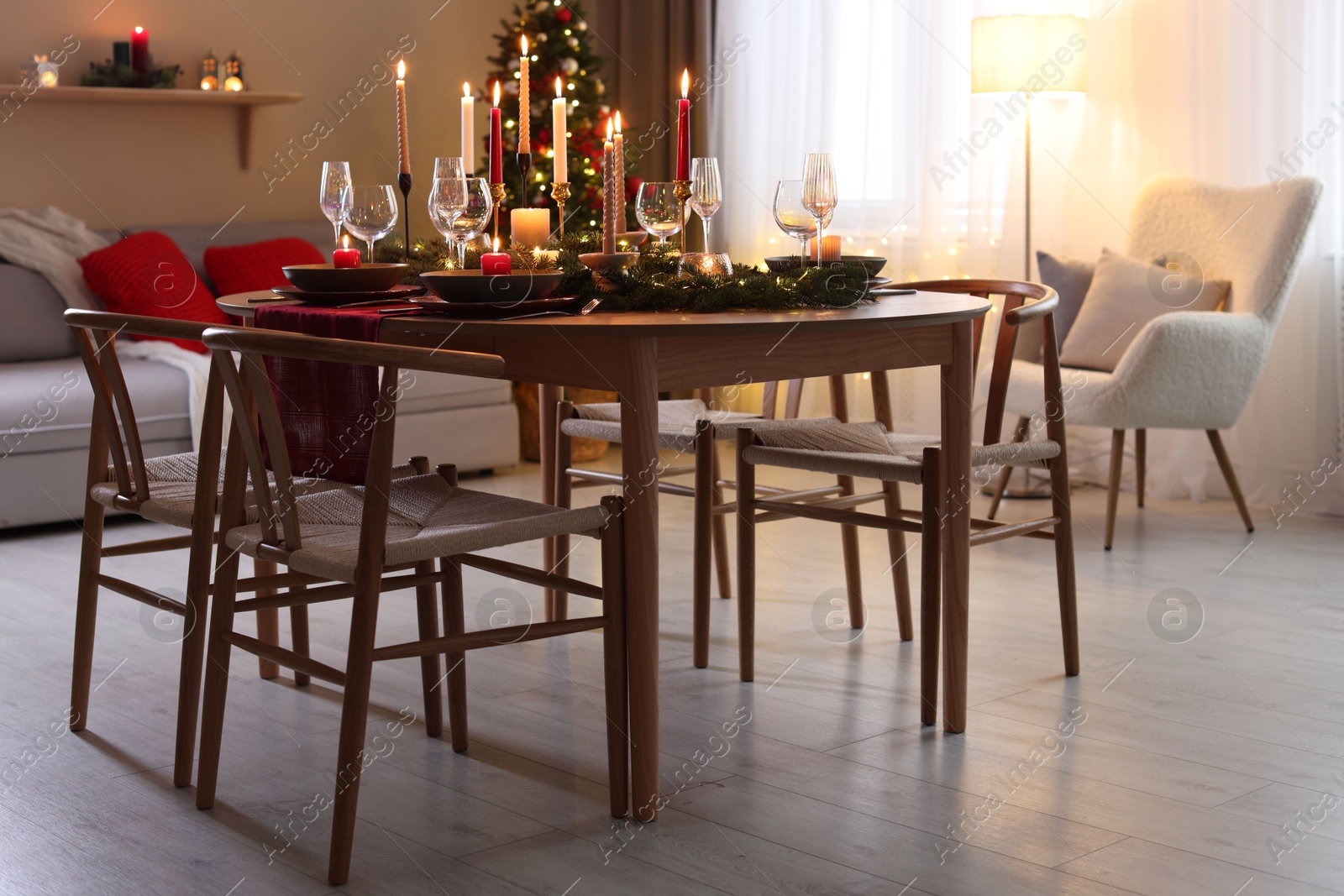 Photo of Festive table setting in room decorated for Christmas. Bokeh effect