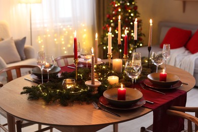 Photo of Festive table setting in room decorated for Christmas. Bokeh effect