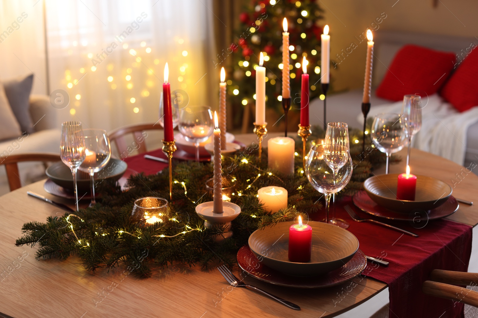 Photo of Festive table setting in room decorated for Christmas. Bokeh effect