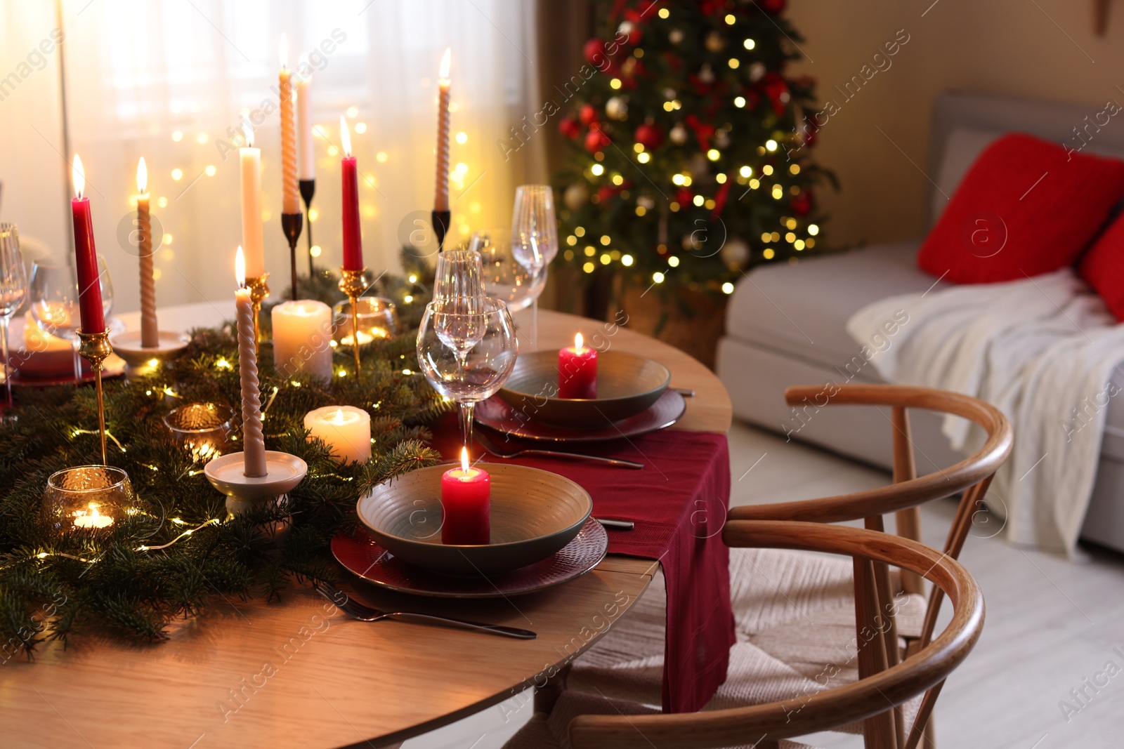 Photo of Festive table setting in room decorated for Christmas. Bokeh effect