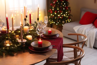 Photo of Festive table setting in room decorated for Christmas. Bokeh effect