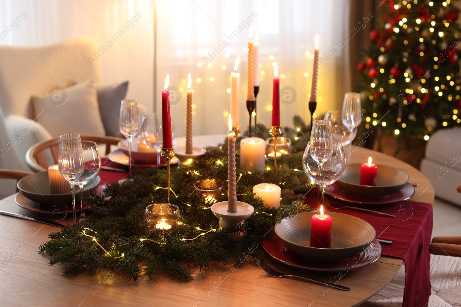 Photo of Festive table setting in room decorated for Christmas. Bokeh effect