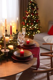 Photo of Festive table setting in room decorated for Christmas. Bokeh effect