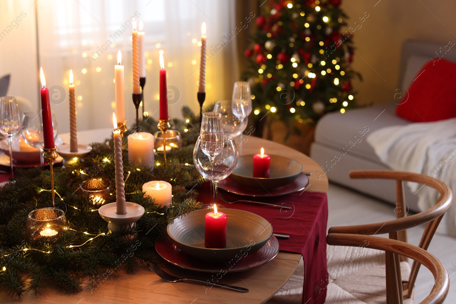 Photo of Festive table setting in room decorated for Christmas. Bokeh effect