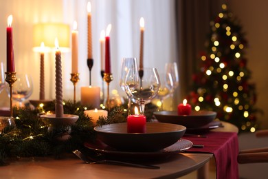 Photo of Festive table setting in room decorated for Christmas. Bokeh effect