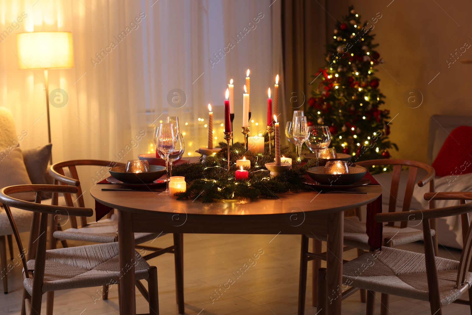 Photo of Festive table setting in room decorated for Christmas. Bokeh effect