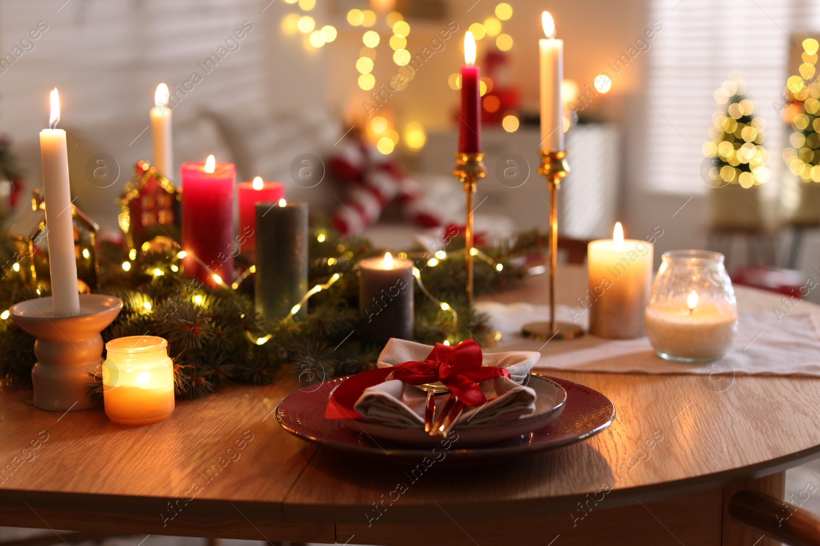 Photo of Festive table setting in room decorated for Christmas, closeup. Bokeh effect