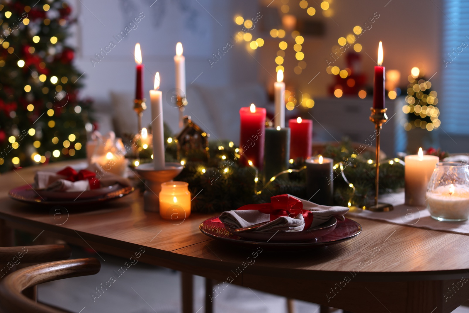 Photo of Festive table setting in room decorated for Christmas. Bokeh effect