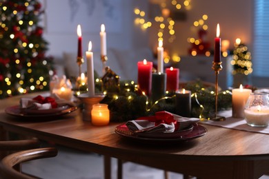 Photo of Festive table setting in room decorated for Christmas. Bokeh effect