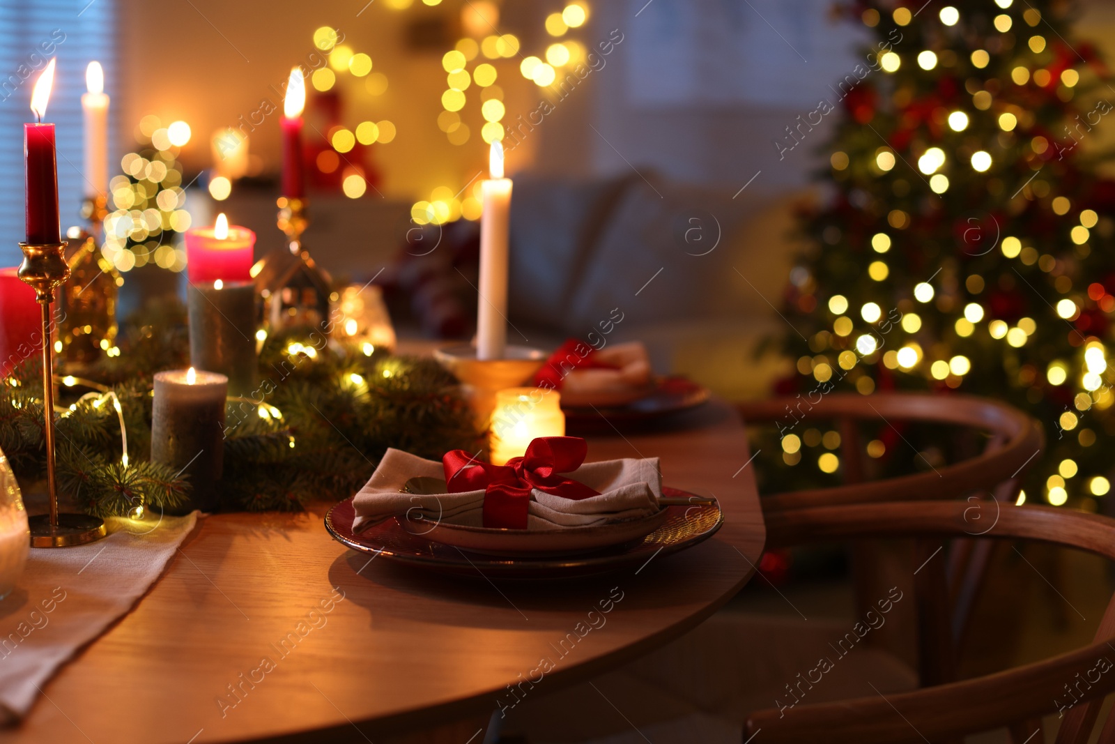 Photo of Festive table setting in room decorated for Christmas. Bokeh effect