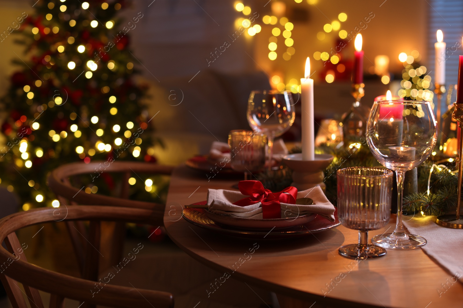 Photo of Festive table setting in room decorated for Christmas. Bokeh effect