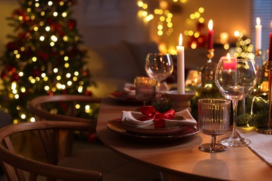 Photo of Festive table setting in room decorated for Christmas. Bokeh effect