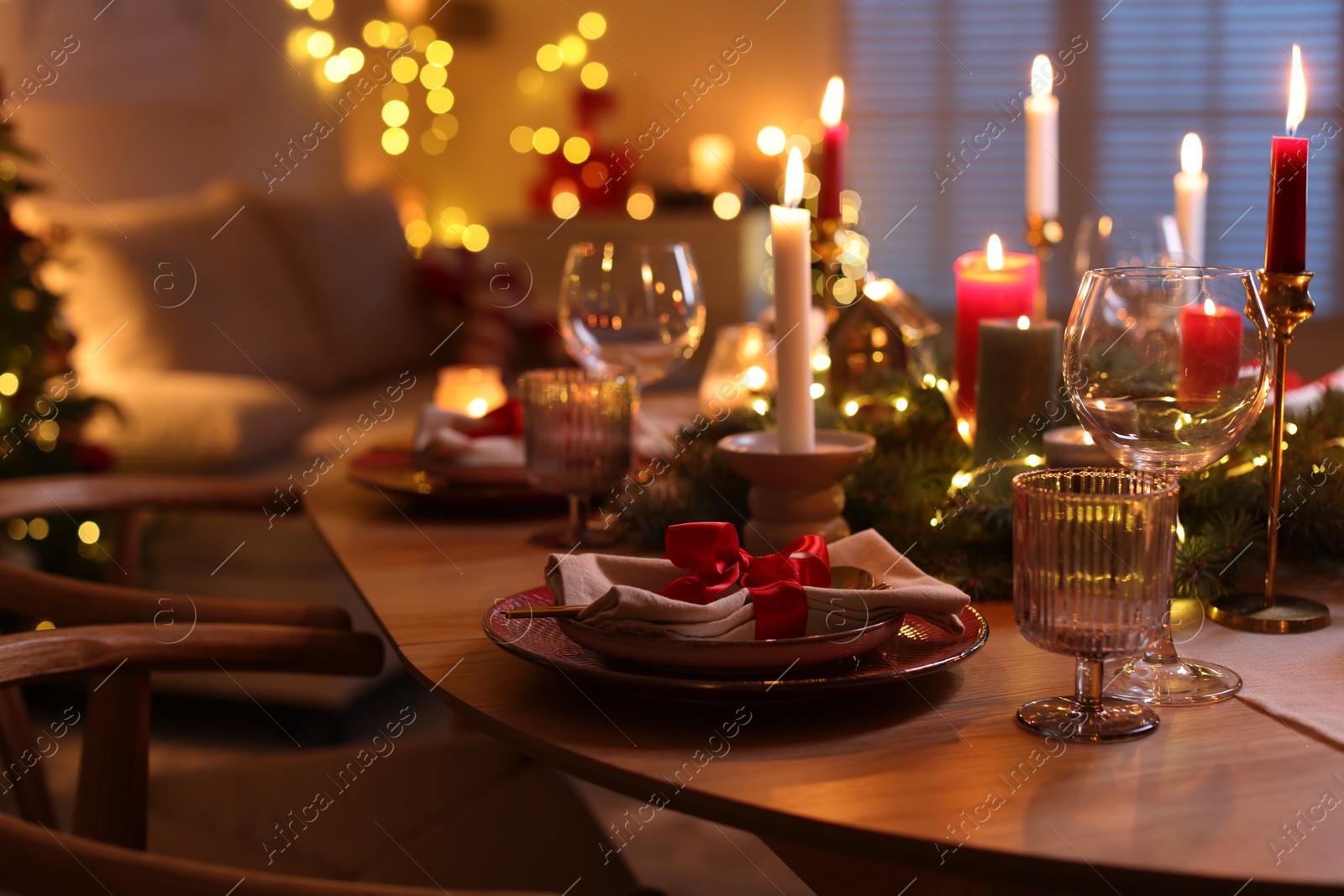 Photo of Festive table setting in room decorated for Christmas. Bokeh effect